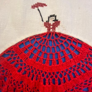 Può includere: Tovaglietta all'uncinetto rossa con sfondo bianco con un ricamo a punto croce di una donna che tiene un ombrello.