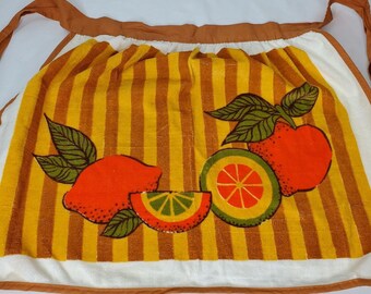Könnte beinhalten: Ein vintage Küchentuch mit braunem und gelbem Streifenmuster und einem Design aus Zitronen und Limetten. Das Tuch hat braune Bänder.