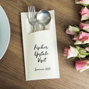 May include: A white paper napkin with a silver fork and spoon inside. The napkin has the text "Fischer Upstate Visit Summer 2020" printed on it.