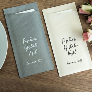 May include: Two gray and cream linen envelopes with the text "Fischer Upstate Visit Summer 2020" printed on them.