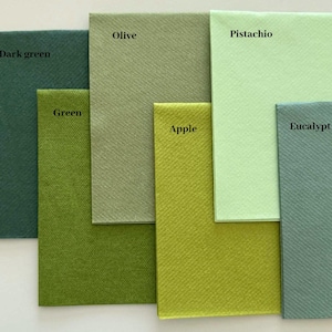 Op de afbeelding: Een collectie van zes vierkante papieren servetten in verschillende tinten groen, gelabeld Dark green, Olive, Green, Apple, Pistachio en Eucalypt. Elk servet heeft een duidelijk getextureerd oppervlak en een unieke groene tint, gerangschikt in een overlappend patroon.