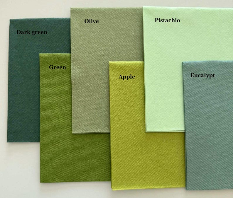 Op de afbeelding: Een collectie van zes vierkante papieren servetten in verschillende tinten groen, gelabeld Dark green, Olive, Green, Apple, Pistachio en Eucalypt. Elk servet heeft een duidelijk getextureerd oppervlak en een unieke groene tint, gerangschikt in een overlappend patroon.