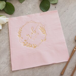 Pu&ograve; includere: Tovagliolo di carta rosa con una cornice geometrica dorata e un motivo floreale. La cornice include il testo "rwb" e la data "10/27/18".