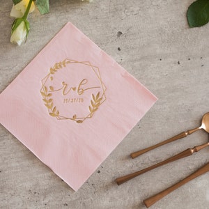 Pu&ograve; includere: Tovagliolo di carta rosa con una cornice geometrica dorata e un motivo floreale. La cornice include le iniziali "r & b" e la data "10.27.18".