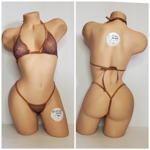 Puede incluir: Un bikini marrón de malla con un top halter y una parte inferior de tanga. El bikini está en un maniquí. El bikini tiene un estampado de piel de serpiente.