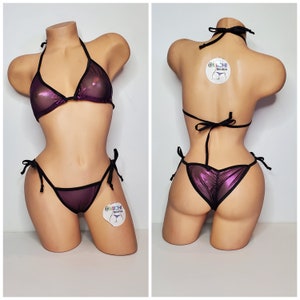 May include: A purple metallic bikini with black trim and ties. The bikini top is a triangle style and the bottom is a cheeky style with a gathered front.