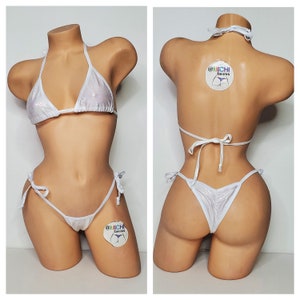 May include: White bikini with a halter top and a tie-side bottom. The bikini is made of a shiny, iridescent fabric. The bikini is shown on a mannequin.