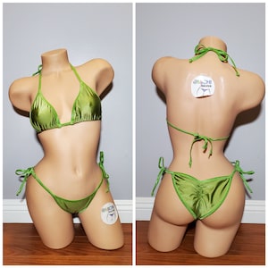 May include: Green satin bikini with adjustable straps and ties. The bikini top is a triangle style and the bottom is a cheeky style. The bikini is shown on a mannequin.