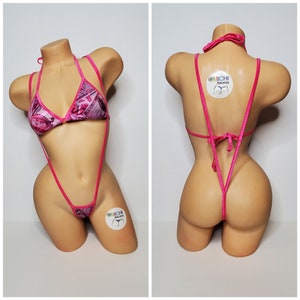 Puede incluir: Traje de baño estampado en rosa y gris con un top halter y una parte inferior de cuerda. El traje de baño tiene una pequeña etiqueta con el texto "@MICHI bikinis".