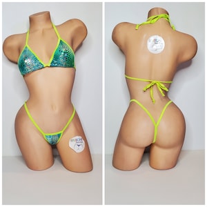 May include: A green and blue iridescent bikini with neon green straps. The bikini top is a triangle style and the bottom is a cheeky style. The bikini is on a mannequin.