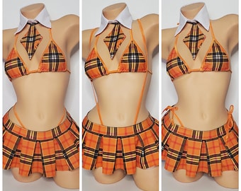 Op de afbeelding: Een geruite rok en een bijpassend bikini-top met een witte kraag en stropdas. De set is oranje, zwart en wit.