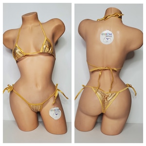 May include: Gold bikini with a snakeskin pattern. The top is a triangle style with adjustable straps. The bottom is a cheeky style with ties on the sides. The bikini is made of a shiny, stretchy fabric.