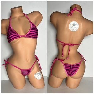 May include: Pink and black striped bikini with adjustable straps and ties. The bikini top is a triangle style and the bottom is a cheeky style. The bikini is made of a shiny, silky fabric.