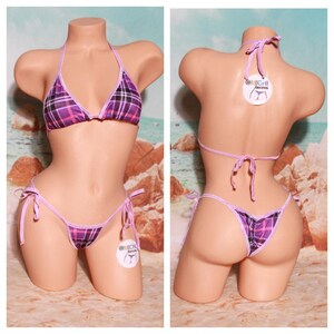 Puede incluir: Bikini de cuadros morado y negro con lazos ajustables. La parte superior e inferior del bikini tienen un ribete de color morado claro. La parte inferior del bikini tiene un corte de talle bajo.