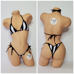May include: Black and white striped bikini with a halter top and a cheeky bottom. The bikini is tied at the sides and has a small logo on the bottom.