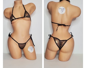 May include: Gold and black bikini with a mesh design. The bikini top has a halter style and the bottom has a tie side design. The bikini is on a mannequin.