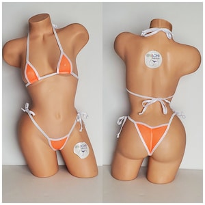 May include: Orange and white bikini with a mesh design and adjustable straps. The bikini is on a mannequin. The tag on the bikini reads "@Michi Bikinis".