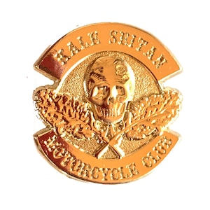 Puede incluir: Parche de club de motociclistas de color dorado con un diseño de calavera y huesos cruzados. El texto "Half Shitan Motorcycle Club" está escrito alrededor de la calavera.