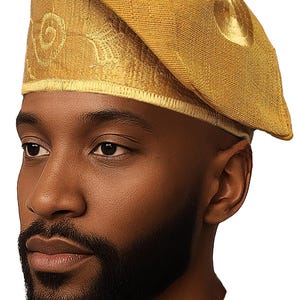 May include: A gold-colored beret with embroidered detailing on the brim and a circular design on the side. The beret is made of a textured fabric and has a slightly angled shape. The hat is a traditional style.