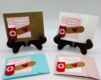 Puede incluir: Cuatro tarjetas hechas a mano con fondo marrón, blanco, azul y rosa. Cada tarjeta presenta una venda roja y blanca, una botella roja con una cruz blanca y un corazón rojo. Las tarjetas tienen el texto "Happy Nurses' Day!"