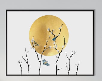 May include: A white canvas print with a gold circle and black branches with white flowers and blue birds. The print is hanging on a white wall above a beige couch with white pillows.