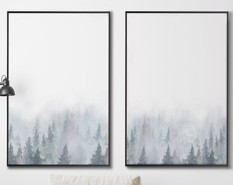 Könnte beinhalten: Zwei gerahmte Aquarellbilder einer nebligen Waldszene mit weißem Hintergrund und schwarzem Rahmen. Die Bilder hängen an einer weißen Wand über einem weißen Sofa mit Kissen und einer Wolldecke.