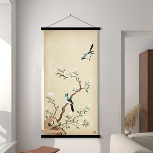 Peut inclure: Une tapisserie murale beige avec un cadre noir présente une illustration peinte à la main d'une branche en fleurs avec deux oiseaux bleus et noirs perchés sur les branches. L'arrière-plan est de couleur beige clair.