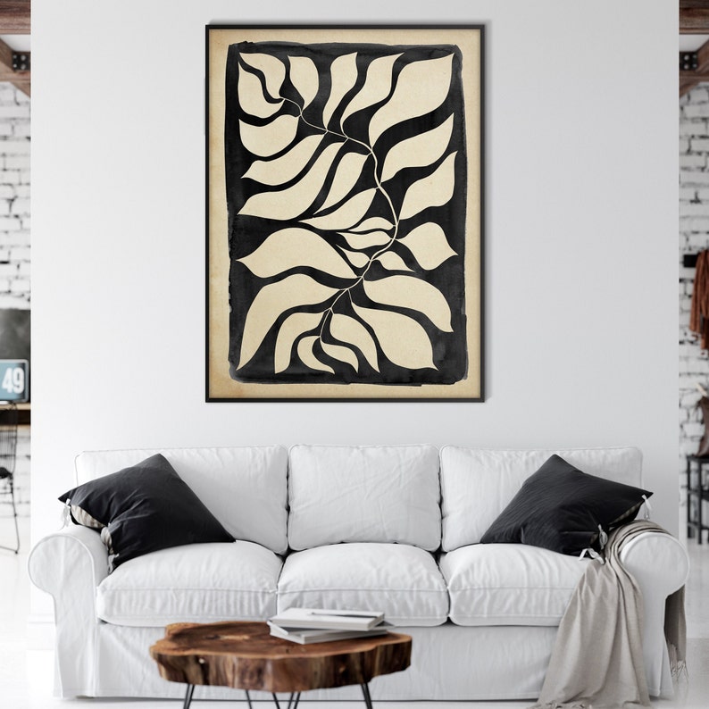 May include: Black and white abstract art print featuring a stylized image of leaves. The leaves are outlined in black and filled in with a cream color. The print has a vintage, hand-drawn aesthetic.