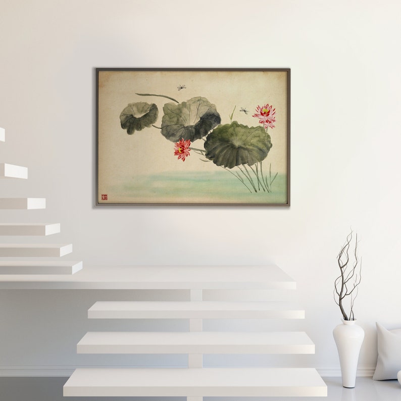 May include: A framed watercolor painting depicts lotus flowers and leaves in a serene pond setting. The artwork features large, green lily pads, vibrant pink flowers, and delicate dragonflies. The painting is set against a neutral background, creating a calming aesthetic.