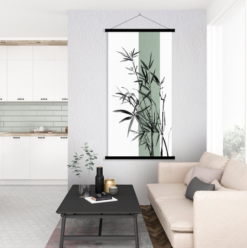 May include: A black and white wall hanging with a green background featuring a stylized illustration of bamboo plants. The hanging is displayed in a modern living room with a couch and coffee table.