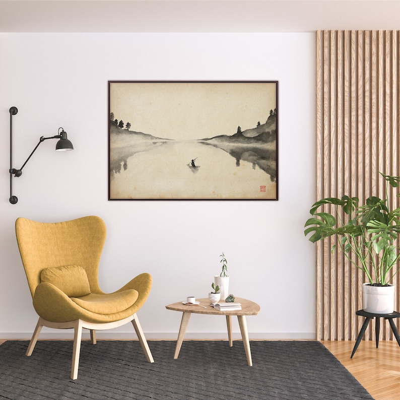Puede incluir: Una pintura minimalista en acuarela en blanco y negro de una escena de lago con una sola figura en un bote. La pintura est&aacute; enmarcada en un marco de madera marr&oacute;n y cuelga de una pared blanca sobre un sill&oacute;n amarillo y una mesa de caf&eacute; de madera.