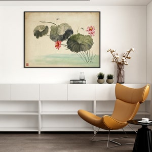 May include: A framed watercolor painting of lotus flowers and leaves in a serene, Asian-inspired style. The artwork features pink blossoms, large green leaves, and dragonflies, set against a soft, neutral background. The painting is displayed above a white cabinet.