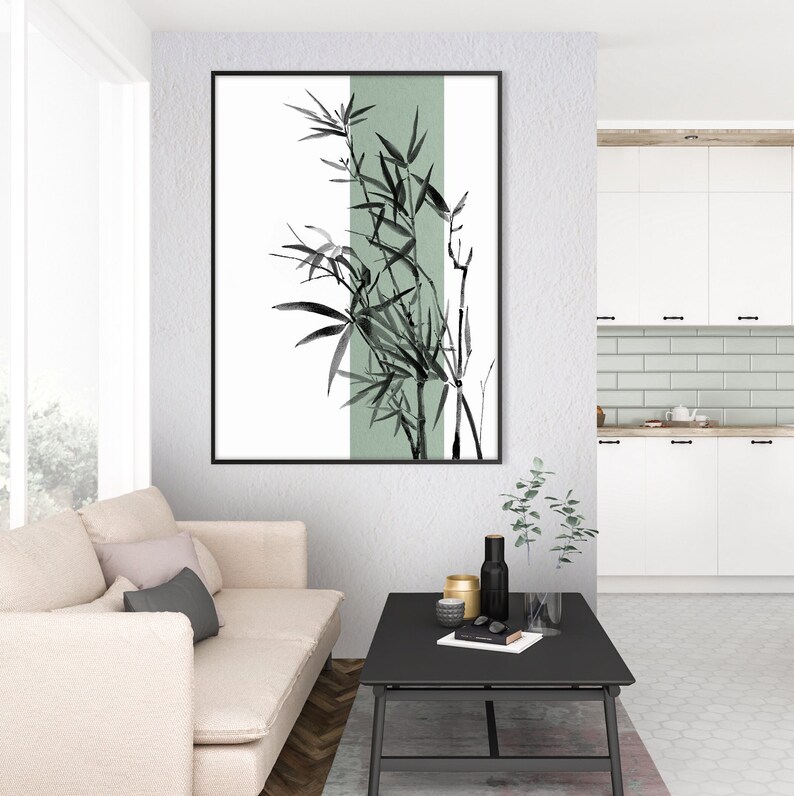 May include: A black and white illustration of bamboo plants with a green background. The illustration is framed and hanging on a white wall in a living room setting.