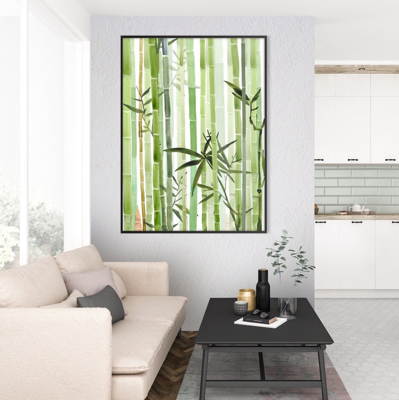 May include: A framed watercolor painting of a bamboo forest with green and white hues. The painting is hanging on a white wall in a living room setting.