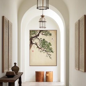 Pode incluir: Uma obra de arte emoldurada com uma pintura em aquarela de um galho de pinheiro com agulhas verdes e pequenos p&aacute;ssaros. A obra de arte &eacute; exibida em um corredor com uma mesa de madeira r&uacute;stica, bancos decorativos e lanternas suspensas.