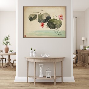 May include: A framed watercolor painting of lotus flowers and leaves in a serene, Asian-inspired style. The artwork features large, green lily pads, delicate pink flowers, and small dragonflies, set against a soft, cream-colored background.