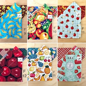 May include: Six fabric squares with different fruit patterns. The squares are folded in half to form a triangle shape. The patterns include bananas, watermelon, apples, cherries, lemons, and strawberries.