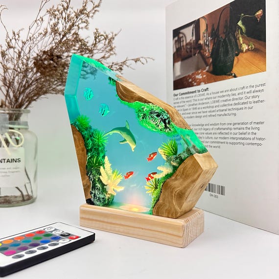 A genuinely sculptural epoxy-resin lamp where a dolphin leaps through a glowing slice of wood — the kind of piece that stops guests mid-sentence.