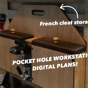 May include: A wooden pocket hole workstation with two storage compartments, each with a wooden knob. The workstation has a French cleat storage system and the text "POCKET HOLE WORKSTATION DIGITAL PLANS!" is printed on the front.