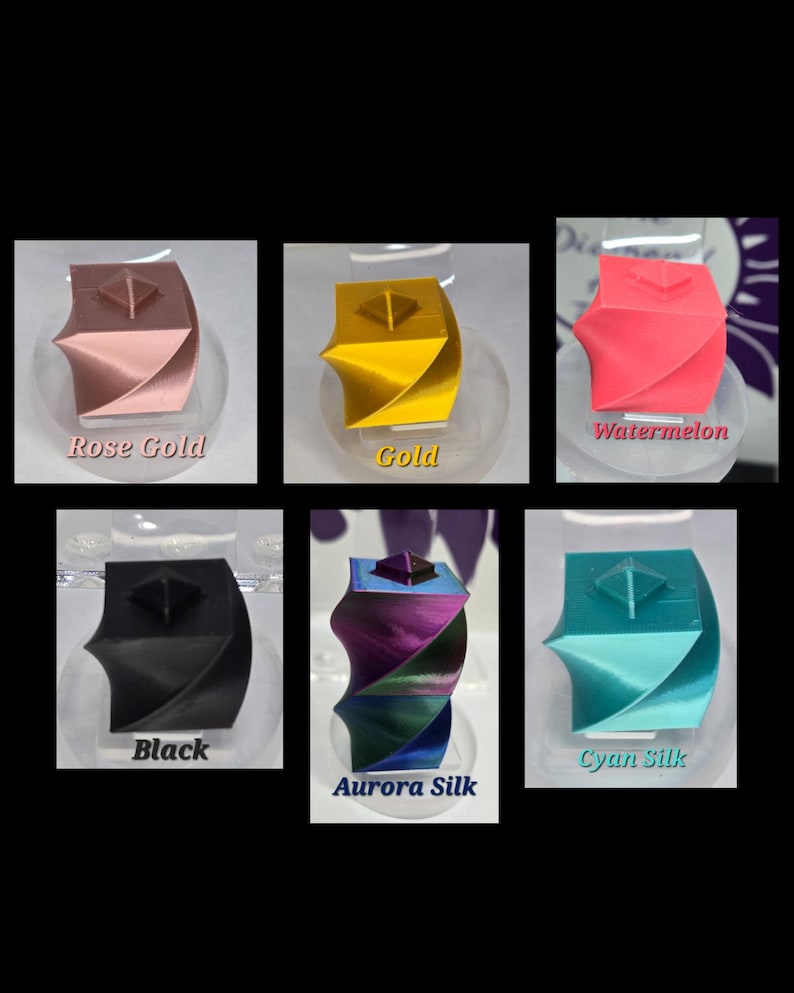 May include: A collection of six 3D-printed geometric sculptures in various colors, including rose gold, gold, watermelon, black, aurora silk, and cyan silk. Each sculpture has a square top and a twisted, curved design, displayed on a clear stand.