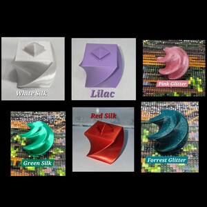 May include: A collection of six 3D-printed objects in various colors and finishes. The objects include white silk, lilac, pink glitter, green silk, red silk, and forest glitter. Each object has a unique, abstract design with text labels.