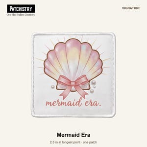 May include: A square white patch featuring a central illustration of a pink iridescent seashell adorned with a pink ribbon bow and small pearls. The text "mermaid era." is printed below in a pink script font. The patch measures 6.35 cm.