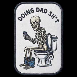 Peut inclure: Un écusson brodé rectangulaire à fond blanc et bordure sombre. Il représente un squelette assis sur des toilettes, regardant un smartphone, avec un jean bleu autour des chevilles. Le texte DOING DAD SH*T est inscrit au-dessus du squelette.