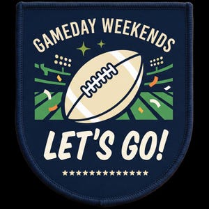 Op de afbeelding: Een donkerblauwe, schildvormige patch met een crèmekleurige American football in het midden. De tekst GAMEDAY WEEKENDS en LET'S GO! staat in crèmekleurige letters. Het ontwerp bevat een groen stadionveld, stadionverlichting en oranje confetti.