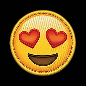Pode incluir: Um emblema circular amarelo com um rosto emoji bordado, apresentando dois olhos em forma de coração vermelho e uma boca larga e sorridente em castanho escuro. O design tem uma aparência texturizada e costurada com uma borda amarela.