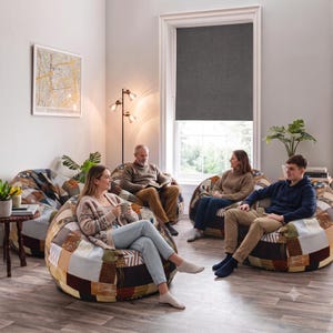 May include: Four large, round bean bag chairs featuring a patchwork design composed of various fabric squares in shades of brown, tan, cream, and blue. Each chair has a soft, stuffed construction and a textured surface with diverse patterns.