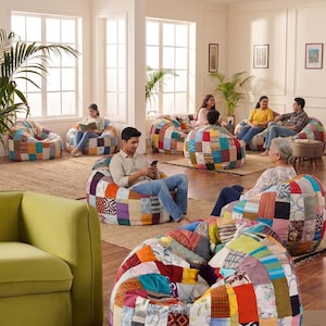 May include: A collection of round, low-profile bean bag chairs featuring a patchwork design composed of various fabric squares in diverse colors, patterns, and textures, including floral, geometric, and solid prints arranged in a grid-like layout.