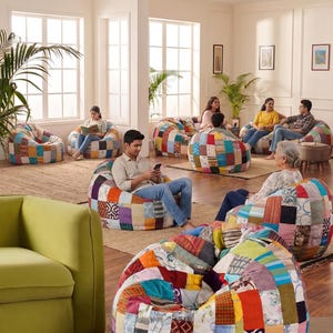 May include: A collection of round, low-profile bean bag chairs featuring a patchwork design composed of various fabric squares in diverse colors, patterns, and textures, including floral, geometric, and solid prints arranged in a grid-like layout.