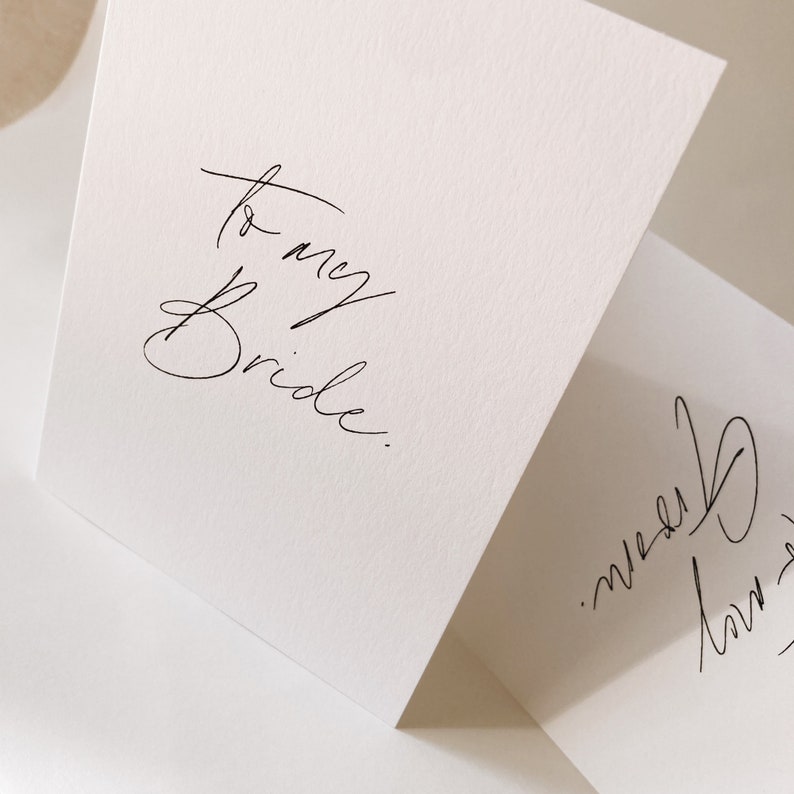 May include: A white card with the handwritten message "to my Bride."  The card is folded in half and the bottom half of the card is visible with a handwritten signature.