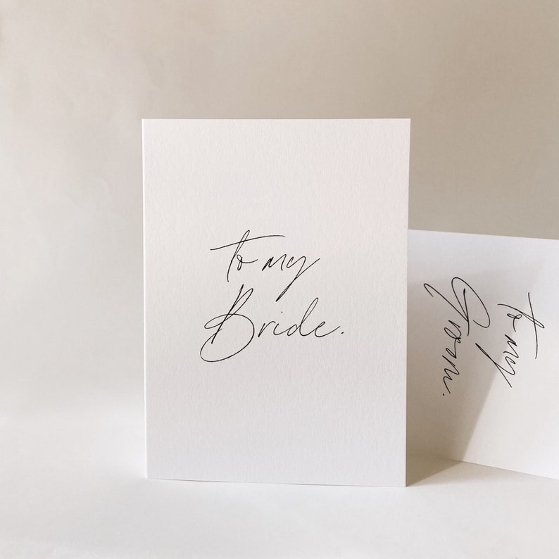 May include: A white card with black calligraphy that reads "to my bride."